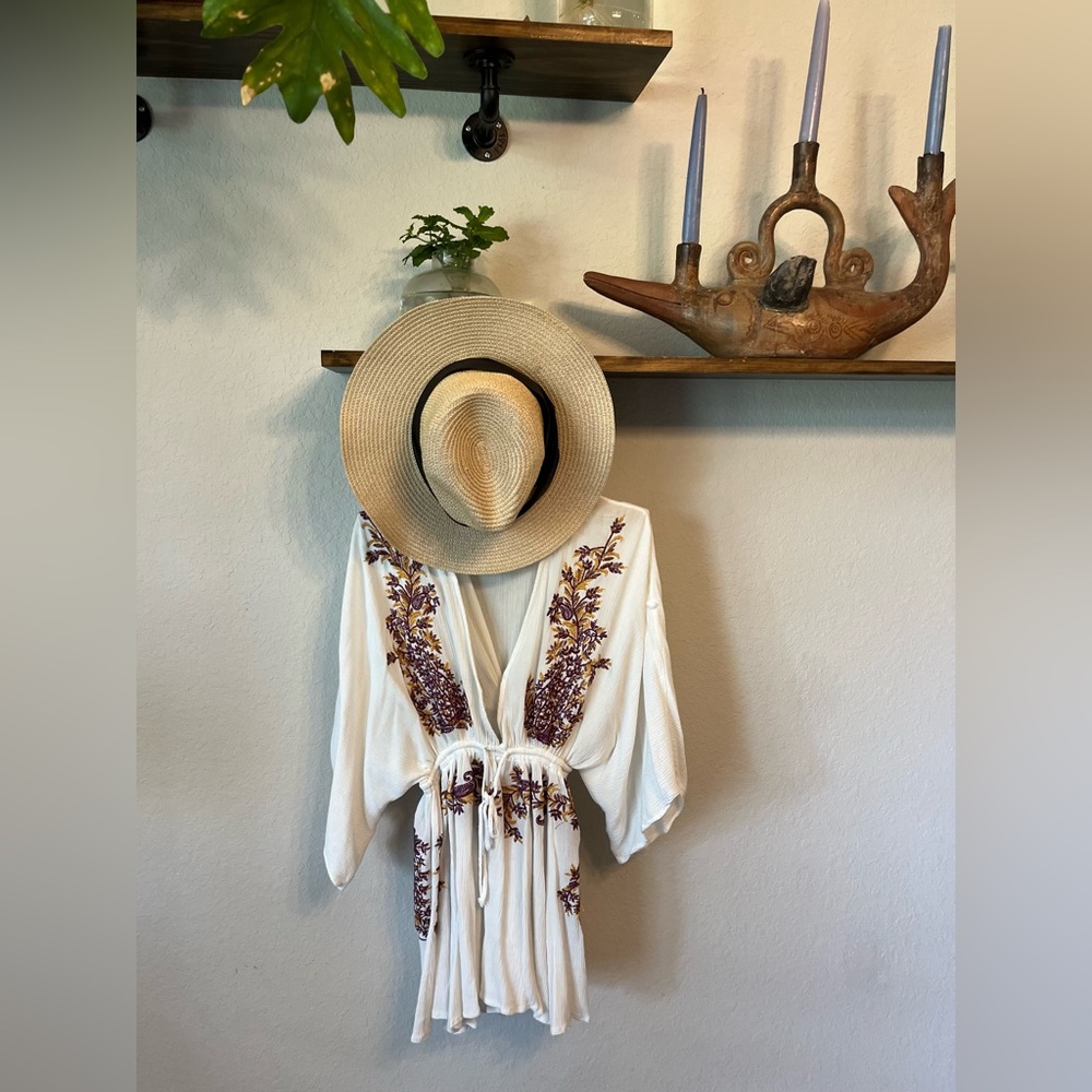Super beachy vibes with this embroidered romper with a tie waist.